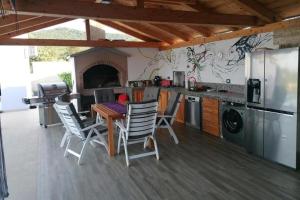 a kitchen with a table and chairs in a kitchen at Family friendly house with a swimming pool Cunski, Losinj - 24170 in Cunski