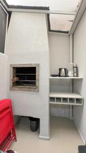 a kitchen with a brick oven in a room at Casa 3 min da praia 2 suítes churrasqueira garagem in Tramandaí