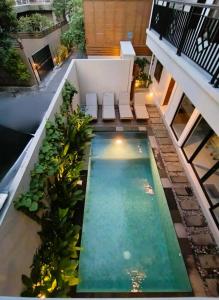 レギャンにあるVilla NANEE - Legian - 5 Bedroom - 5 Bathroomの植物の木が植えられた建物の中央にある屋内プール