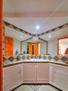 a bathroom with a sink and a large mirror at Casa di Cesare in Playa del Carmen