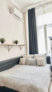 Un dormitorio con una cama con almohadas y una ventana. en Váci Corso Home, en Budapest