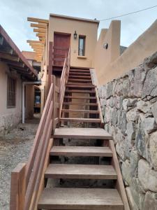 a staircase leading up to a house with a stone wall at Casita para dos in Tilcara