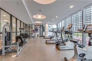a gym with several treadmills and elliptical machines at Panorama Luxe Suites - Prime Downtown Location in Toronto