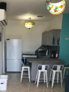 a kitchen with a refrigerator and a counter with stools at Mi Barca Su Casa in Isabela +17 photos