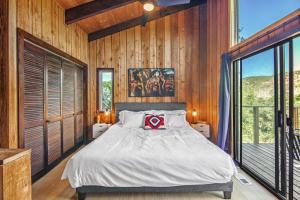 a bedroom with a bed and a large window at Glenwood Springs Mountain Getaway with Hot Tub and Riverfront in Glenwood Springs