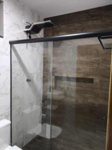 a shower with a glass door in a bathroom at Chalés Vista da Serra in Cunha