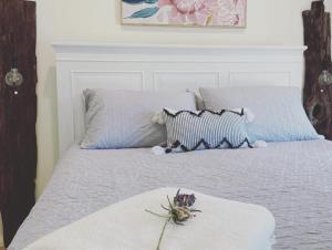 Una cama con dos almohadas y una flor. en Kyogle Farmstay - Charming Country Cottage, en Homeleigh