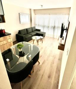 利马MONTERRICO POLO APARTS #21 - Dpto 2 Dorm Frente Embajada de USA的带沙发和玻璃桌的客厅