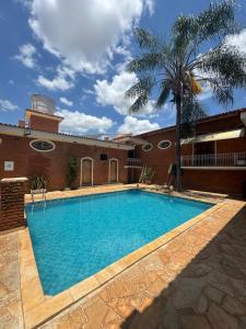 a large swimming pool in front of a building at Pousada Agua Quente in Olímpia