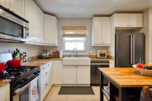 a kitchen with white cabinets and a stainless steel refrigerator at Stylish Central Napa Home with Serene Private Yard in Napa