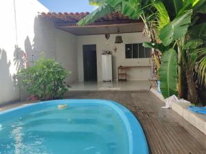 a blue swimming pool in a yard with a house at Casa com piscina e ar condicionado in Seabra