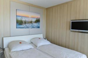 a bedroom with a bed and a flat screen tv at Haus Frische Brise 1507 in Cuxhaven +18 photos
