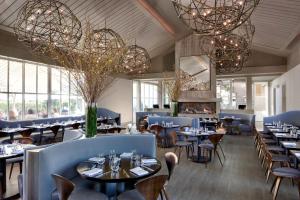 a restaurant with tables and chairs and chandeliers at Solage, Auberge Resorts Collection in Calistoga