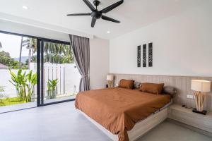a bedroom with a bed with a ceiling fan at Villa Petra in Nathon Bay +37 photos