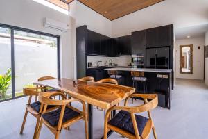 a kitchen with a wooden table and chairs at Villa Petra in Nathon Bay
