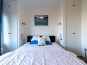 a white bed with a pillow on top of it at Apartment by North Sea with Stunning Views in Middelkerke
