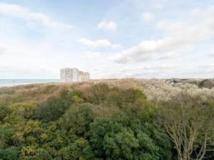 a building on top of a hill with trees at Apartment by North Sea with Stunning Views in Middelkerke