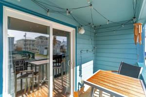 a porch with a wooden table and a dining table at Hang Ten Hideaway, pool, Condo, Parking - 6 person max occupancy in Carolina Beach