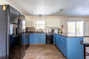 a kitchen with blue cabinets and a black refrigerator at Lakeside Haven 5 BDR Fire Pit Pet Friendly in Tobyhanna