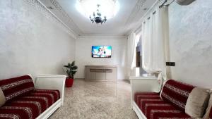 a living room with two couches and a tv at Magnifique maison famiiale moderne spacieuse de 150 m Avec de 3 chambres ,confortables et d un grand salon et terrasse, Idealement situee a 9 min du centre-ville elle se trouve à proximite de la route principale menant a l aeroport Berkane et Saidia in Oujda