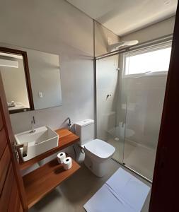 a bathroom with a toilet and a sink and a shower at Mar e descanso - São Miguel in Reduto