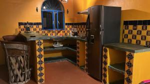 a kitchen with a refrigerator and a sink at Casita Paraiso Escondido in Peñita de Jaltemba +8 photos