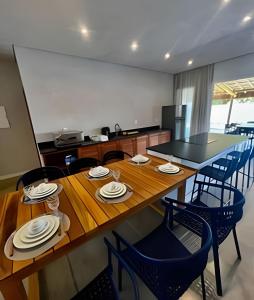 a dining room with a wooden table and chairs at Mar e descanso - São Miguel in Reduto