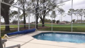 einen Pool mit Blick auf einen Golfplatz in der Unterkunft Villa Sixteen Southern Dunes in Haines City