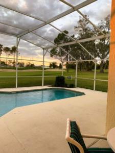 einen Pool mit einem Avisor über einem Tisch und einem Stuhl in der Unterkunft Villa Sixteen Southern Dunes in Haines City