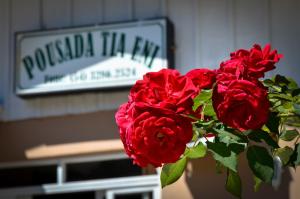 un ramo de rosas rojas delante de un cartel en Pousada Tia Eni, en Gramado