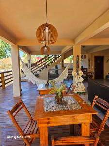 a dining room with a hammock and a table and chairs at Bangalô Suíte Sol do Gostoso in São Miguel do Gostoso