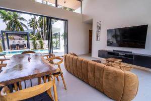 a living room with a couch and a television at Villa Petra in Nathon Bay