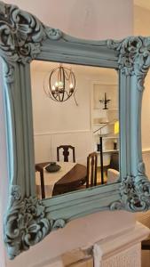 a mirror on a wall with a dining room at Casa Norma Casco Historico in Chascomús