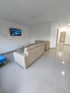 a living room with a couch and a tv on a wall at Casa Vacacional Flandes San Francisco in Flandes