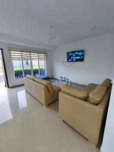 a living room with two couches and a flat screen tv at Casa Vacacional Flandes San Francisco in Flandes +31 photos