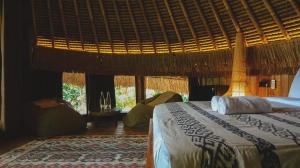 a bedroom with a bed in a room with windows at Alpaca Lodge in Tanah Lot +14 photos
