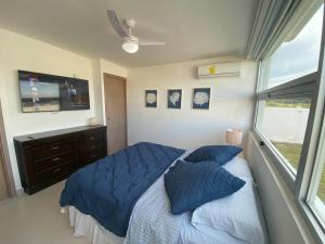 una camera da letto con un letto con cuscini blu e una TV di Summer House a Chame Altre 33 foto