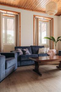 a living room with a blue couch and a coffee table at Oceanview Sunset Retreat in Pilar