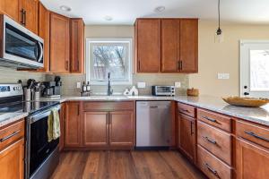 a kitchen with wooden cabinets and stainless steel appliances at The Buckhorn Chalet Hot Tub Arcades 6 Bedroom Fire Place in Albrightsville +59 photos
