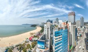a view of a beach and buildings and the ocean at Sunset Hotel in Busan