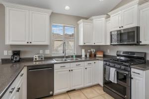 a kitchen with white cabinets and a stove top oven at Spacious Entertainment Dream Home 6 BR Speeps 22 in Syracuse