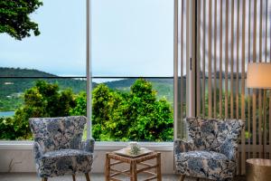 two chairs and a table in front of a large window at 23B Airlie View in Airlie Beach