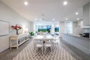 a kitchen and living room with a table and chairs at 23B Airlie View in Airlie Beach
