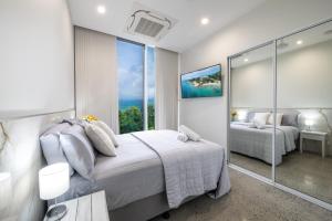 a bedroom with a bed and a large window at 23B Airlie View in Airlie Beach