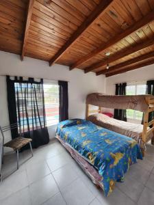 Un dormitorio con dos camas y techo de madera. en Altos de Grecia Cabaña 3, en Villa Carlos Paz