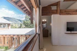 剑川县Shaxi Ancient Town Shiran Mountain Homestay的带阳台的房间，配有电视，可欣赏美景