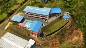 hotel y restaurante el descanso del rey في Restrepo: منظر جوي لمنزل به حوض سباحة