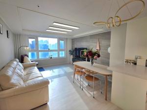 釜山にあるNew Apt 34py 3min to Haeundae Beach LG StanbyMe & Styler Netflix & Sky Capsuleのソファとテーブルのあるリビングルーム