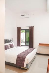 Postel nebo postele na pokoji v ubytování RR -2 Syariah Hotel SLG