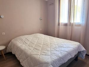 un letto bianco in una camera da letto con finestra di PORT-VENDRES - Appartement T2 avec parking, 4 pers, animaux admis - FR-1-309-266 a Port-Vendres